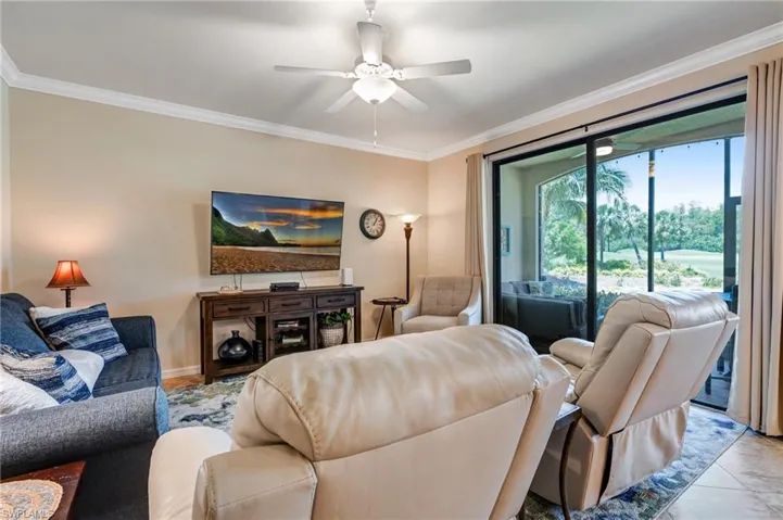Living room featuring ornamental molding, a ceiling fan, and baseboards