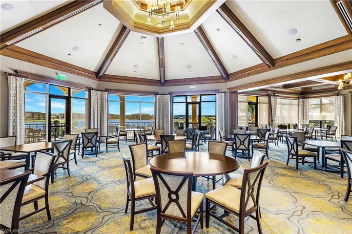 Dining area featuring high vaulted ceiling, a chandelier, beam ceiling, healthy amount of natural light, and carpet