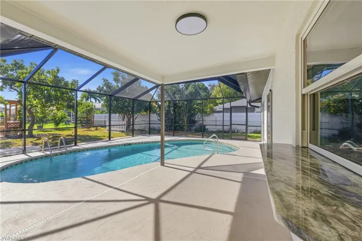 View of pool featuring a patio, a lanai, and a sunroom