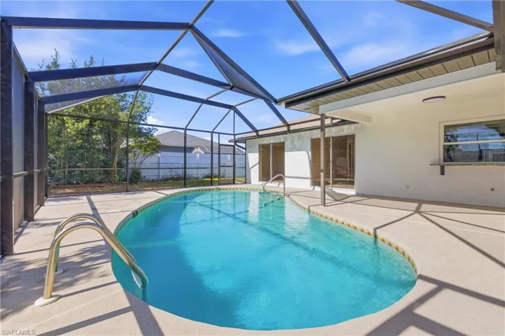 View of pool with a sunroom, a patio, and a lanai