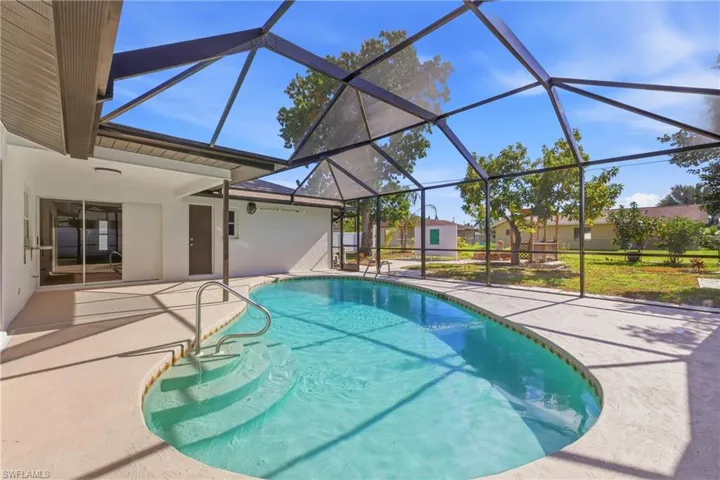 Outdoor pool featuring a sunroom, a patio area, and a lanai