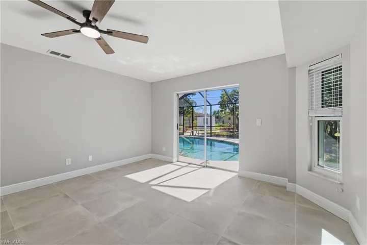 Unfurnished room with a sunroom and ceiling fan