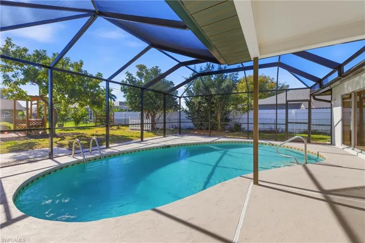 View of swimming pool with a fenced backyard, a patio area, a sunroom, and glass enclosure