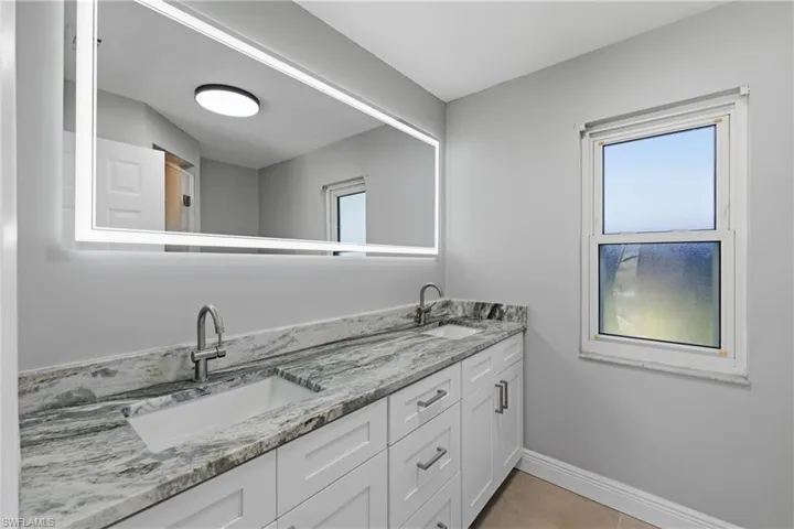 Bathroom featuring double vanity and light tile patterned floors