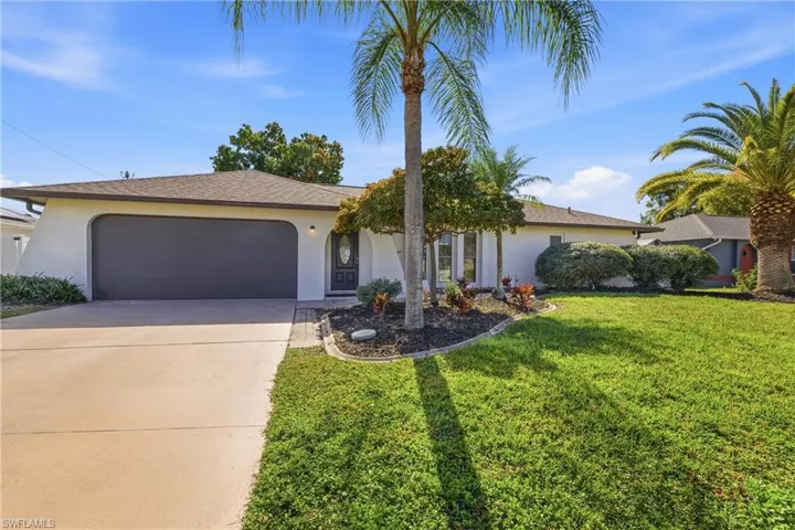 Ranch-style house featuring stucco siding, concrete driveway, a front lawn, and a garage