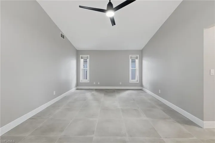 Unfurnished room with lofted ceiling and ceiling fan