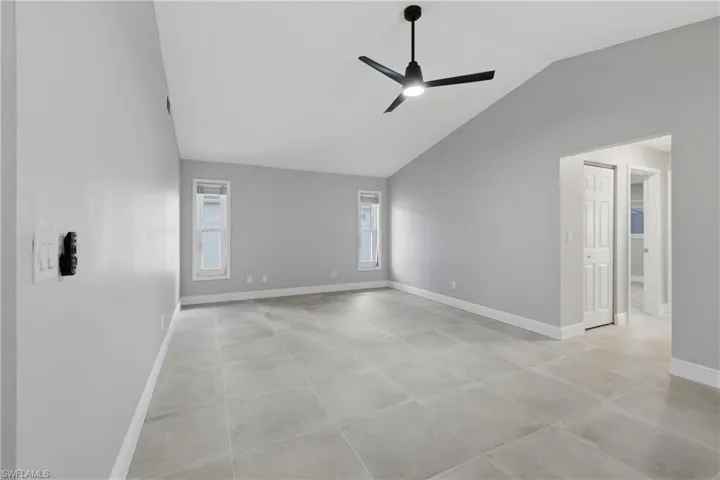 Unfurnished room with vaulted ceiling and a ceiling fan