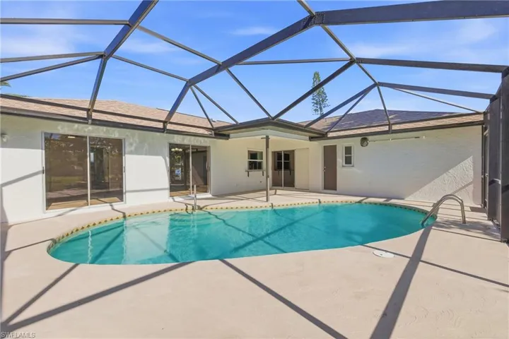 Swimming pool with a sunroom, a patio, and glass enclosure