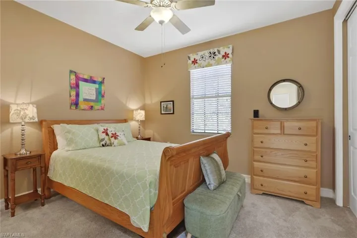 Carpeted bedroom featuring a ceiling fan and baseboards