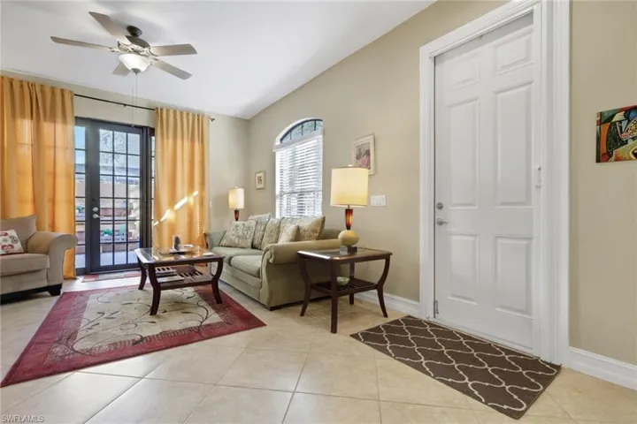 Living room with french doors, light tile patterned flooring, and ceiling fan