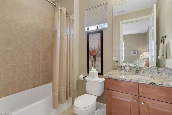 Bathroom with shower / bath combination with curtain and vanity
