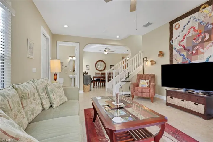 Living room with stairway, ceiling fan, recessed lighting, arched walkways, and tile patterned flooring