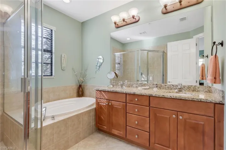 Full bath with a shower stall, double vanity, a garden tub, light tile patterned floors, and recessed lighting