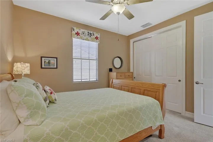 Carpeted bedroom with a closet and ceiling fan