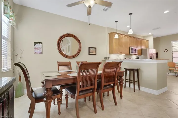 Dining room with light tile patterned floors and a ceiling fan