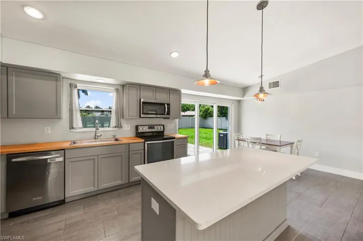 Kitchen with plenty of natural light, a kitchen island, and stainless steel appliances
