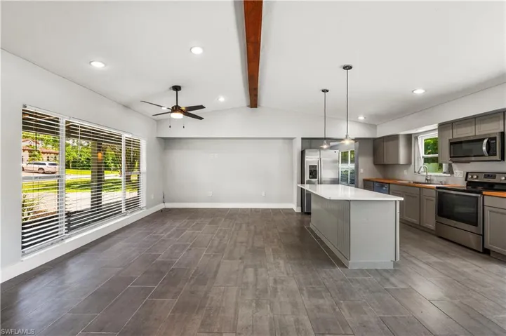Kitchen featuring lofted ceiling with beams, sink, appliances with stainless steel finishes, and wood-type flooring