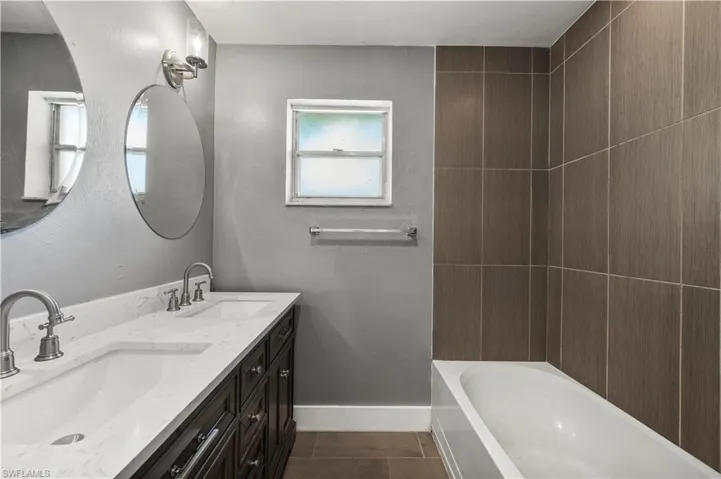 Bathroom featuring tile patterned floors and dual bowl vanity