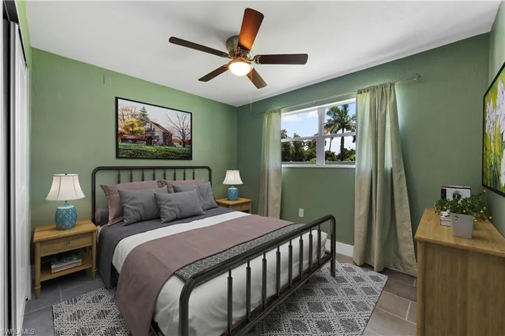 Tiled bedroom featuring ceiling fan