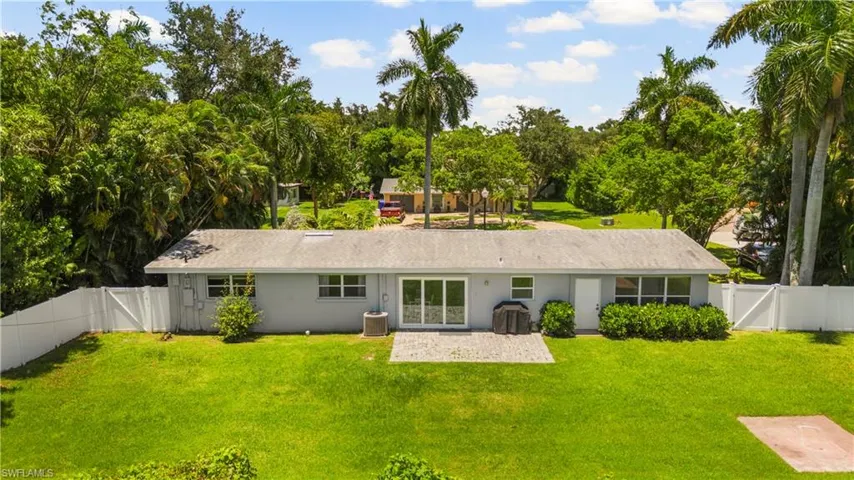 Single story home with central air condition unit and a front lawn