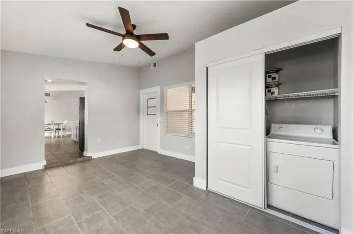 Clothes washing area featuring tile patterned floors, washer / dryer, and ceiling fan