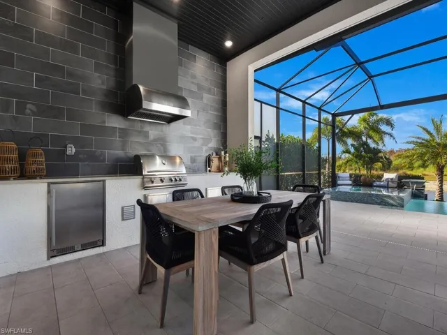 Summer Kitchen - Fully custom summer kitchen on extended lanai with format porcelain tile backsplash to ceiling, gas grill, mini refrigerator & sink