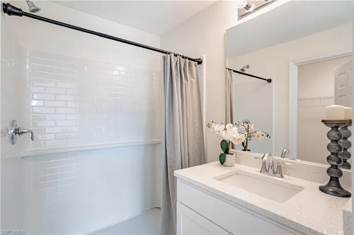 Full bath with vanity, shower / bath combination with curtain, and a spacious closet
