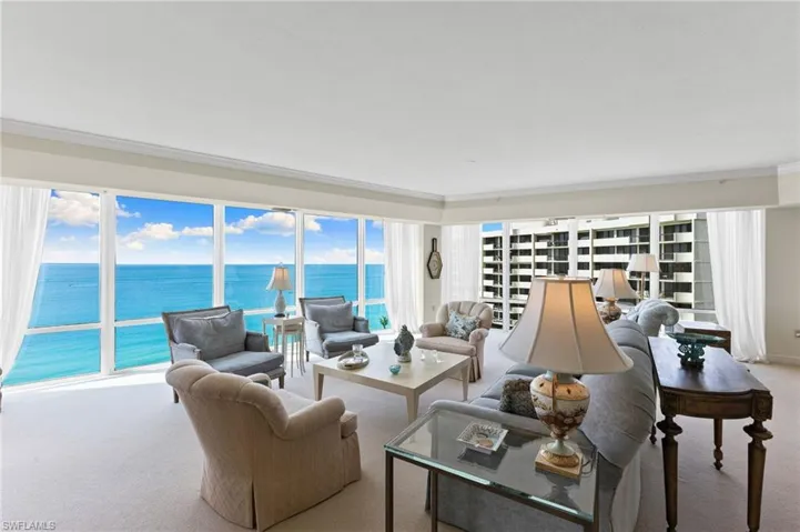 Living room w/ floor-to-ceiling windows overlooking Gulf