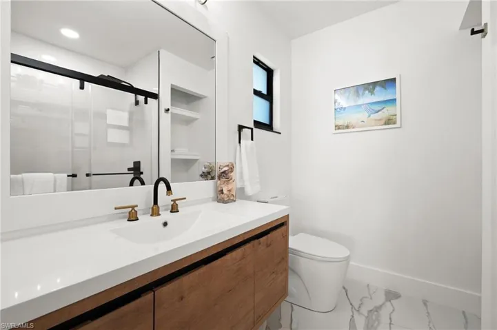 Bathroom featuring vanity, an enclosed shower, and toilet