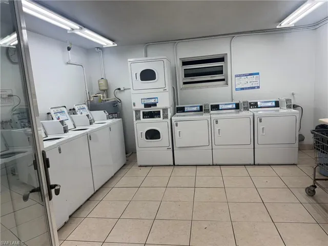 Shared laundry room with washing machine and dryer, water heater, and stacked washing machine and dryer