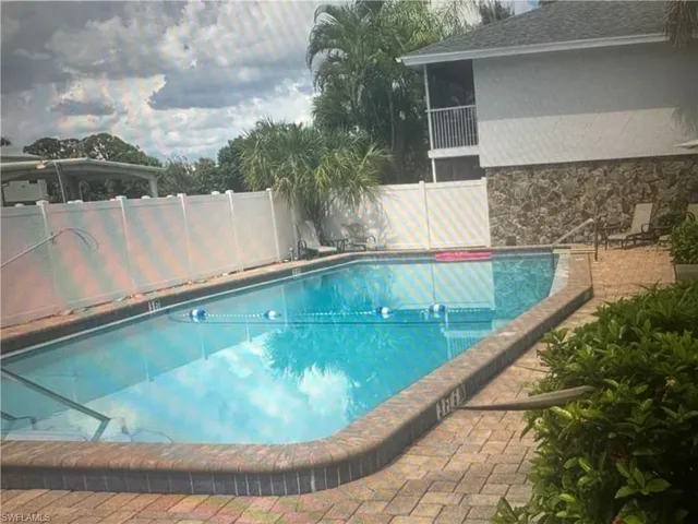 Community pool with a fenced backyard and a patio