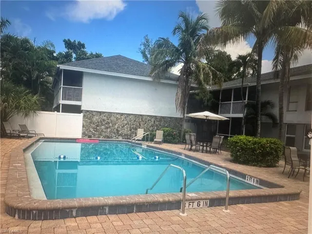 Community pool with a patio and outdoor dining space