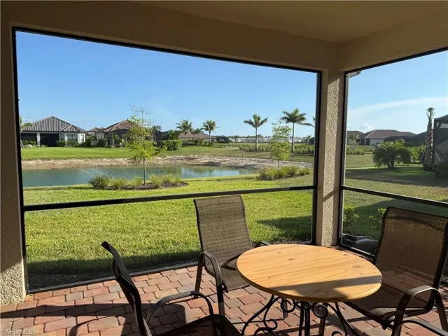 Sunroom featuring a water view and a residential view