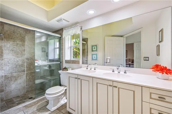 Bathroom featuring vanity, toilet, and a shower with shower door