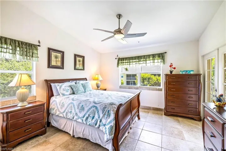 Bedroom featuring multiple windows, ceiling fan, and vaulted ceiling