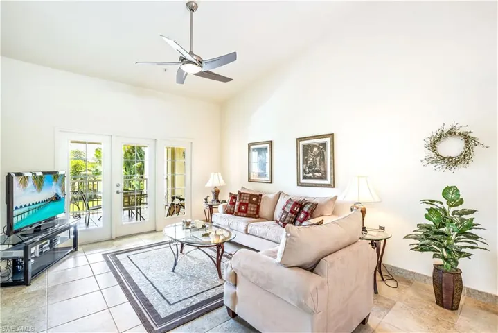 Tiled living room featuring french doors, high vaulted ceiling, and ceiling fan