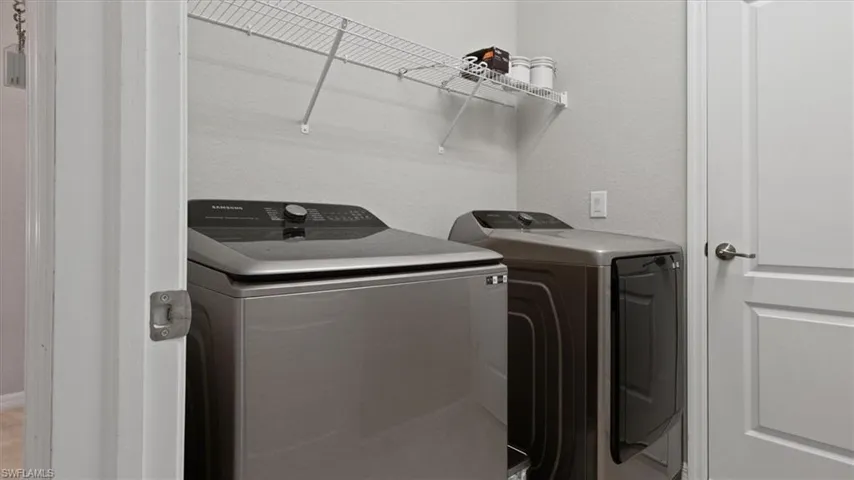 Laundry room with washer and dryer and a textured wall