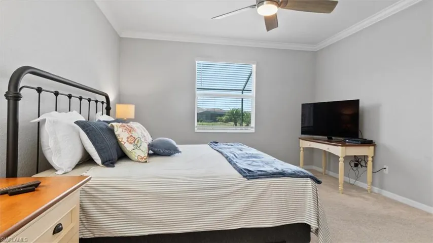 Bedroom featuring carpet flooring, ornamental molding, and ceiling fan