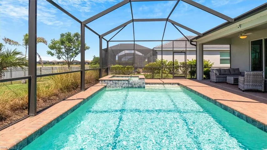 Combined pool / hot tub featuring a sunroom, a lanai, a patio area, and an outdoor lounge area