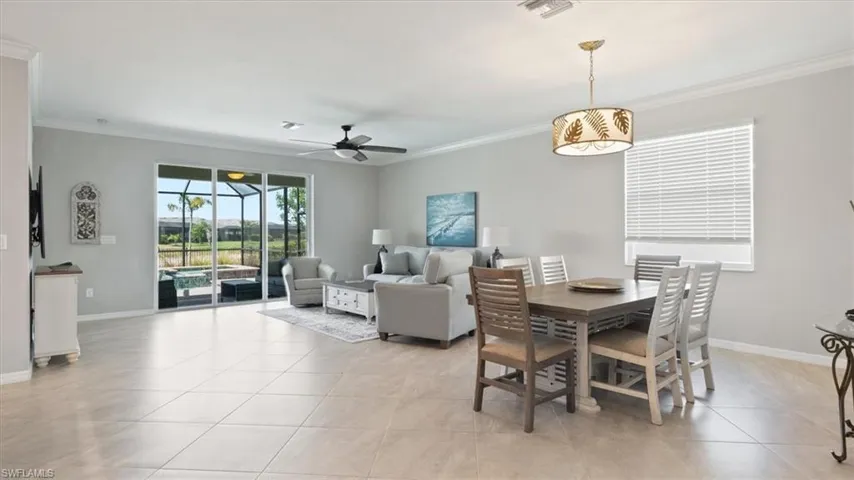 Dining space featuring crown molding, ceiling fan, and light tile patterned flooring