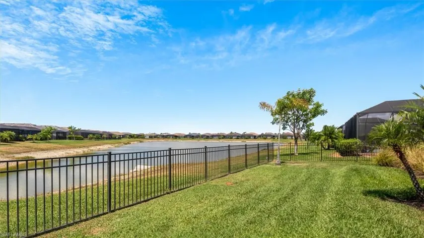 Fenced backyard featuring a residential view and a water view