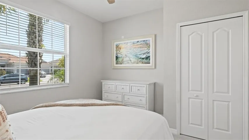 Bedroom featuring light carpet, a closet, and ceiling fan