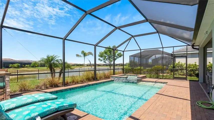 Combined pool / hot tub featuring a sunroom, glass enclosure, and a patio