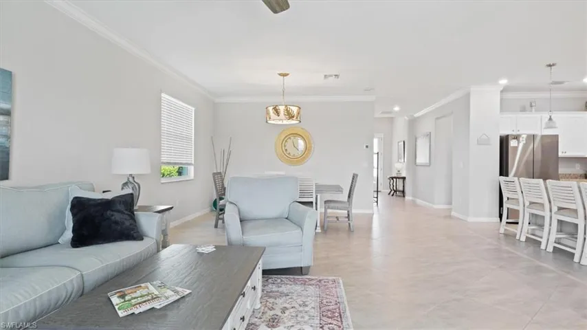 Living room featuring crown molding and ceiling fan