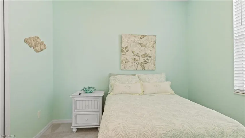 Bedroom featuring carpet floors and baseboards