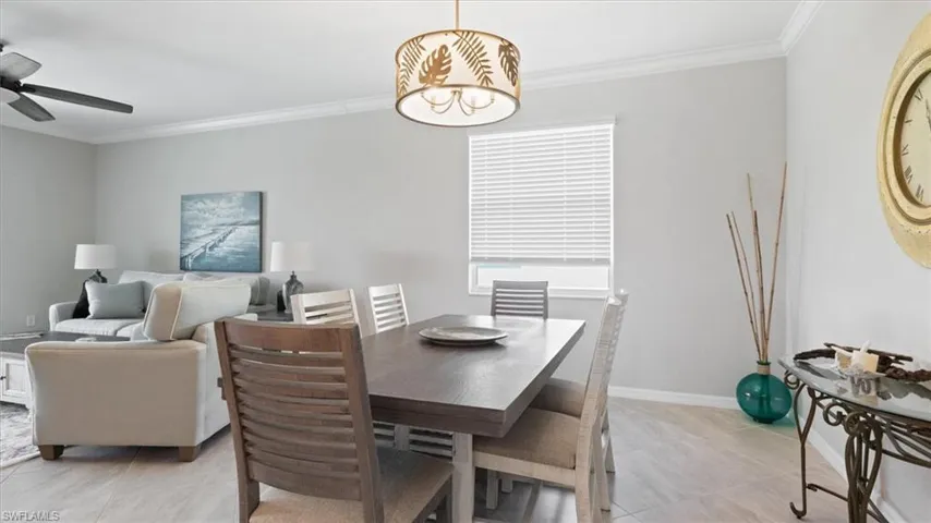 Dining area featuring crown molding, light tile patterned floors, and a ceiling fan