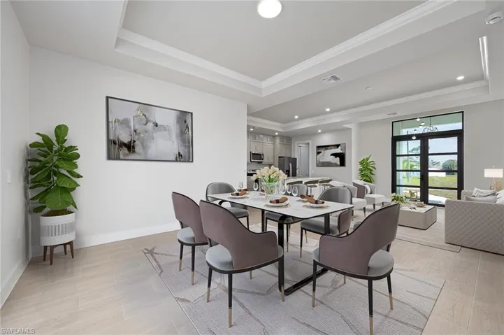 Dining area featuring a tray ceiling, crown molding, and french doors