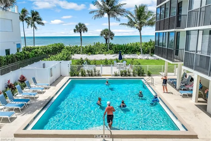 Community pool featuring a patio, a fenced backyard, and a water view