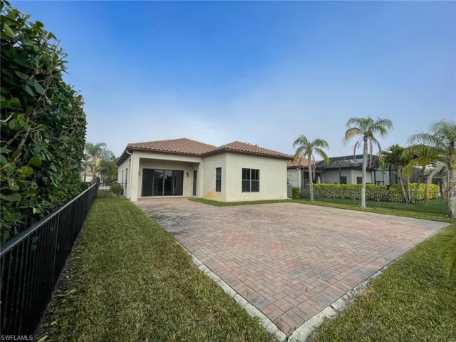 Rear view of house with a garage and a lawn