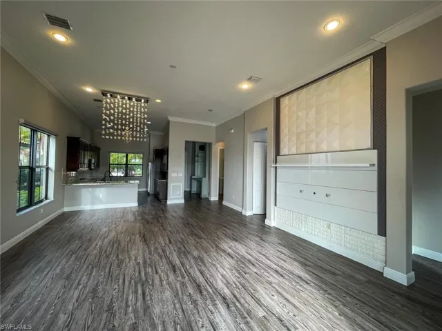 Unfurnished living room with ornamental molding, dark hardwood / wood-style flooring, and sink